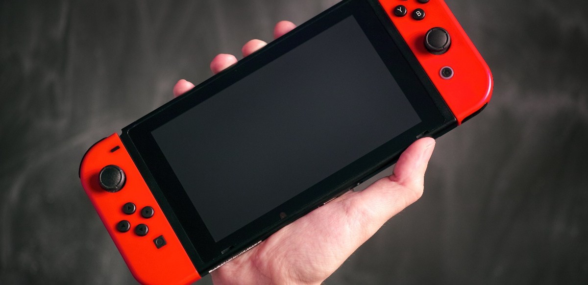 Eine Hand hält die Nintendo Switch in die Luft